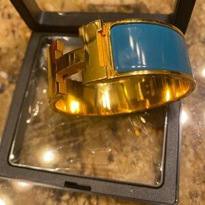 Hermes Elegant H  gold bracelet with teal enamel accent. Stylish and bold design